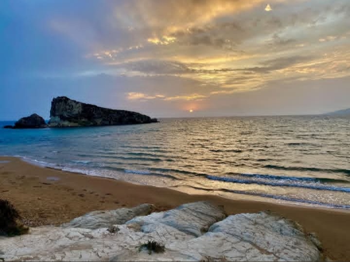 La Rocca di Mollarella al tramonto, con la spiaggia dorata in primo piano