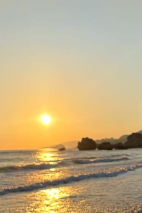 Riflessi dorati del tramonto sulla battigia di Poliscia, con i faraglioni sullo sfondo