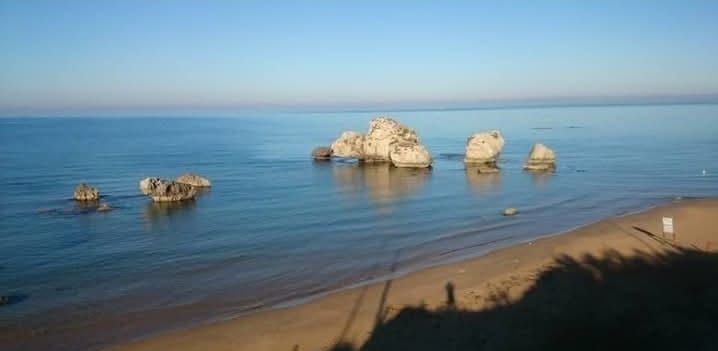 I faraglioni di Poliscia nella quiete del primo mattino, con il mare piatto