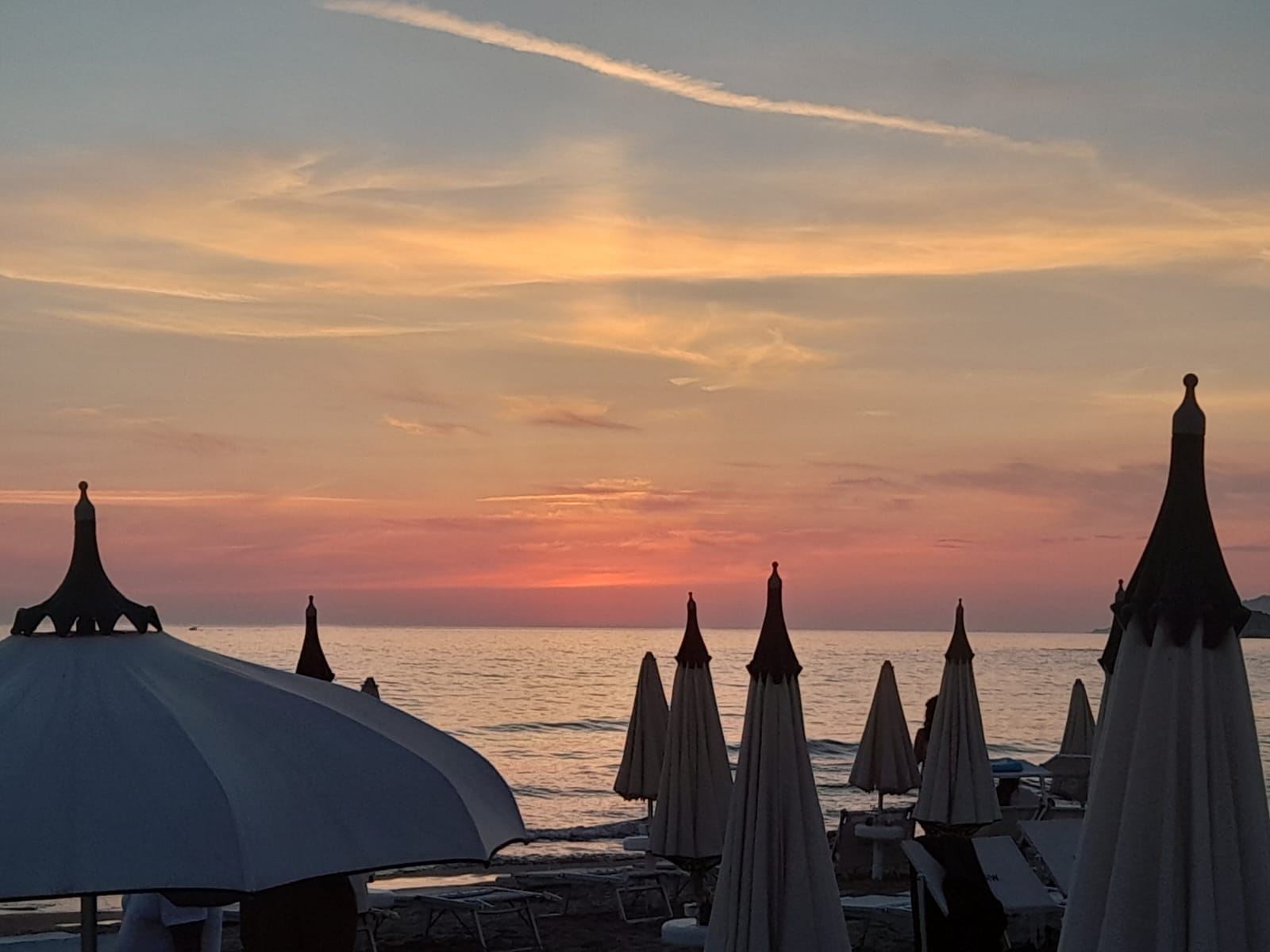 Gli ombrelloni del lido in controluce al crepuscolo
