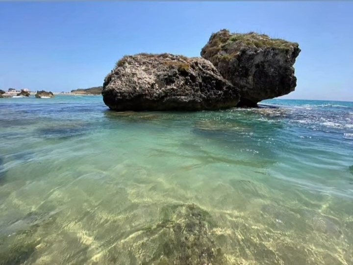 Grande scoglio affiorante nell'acqua turchese di Poliscia