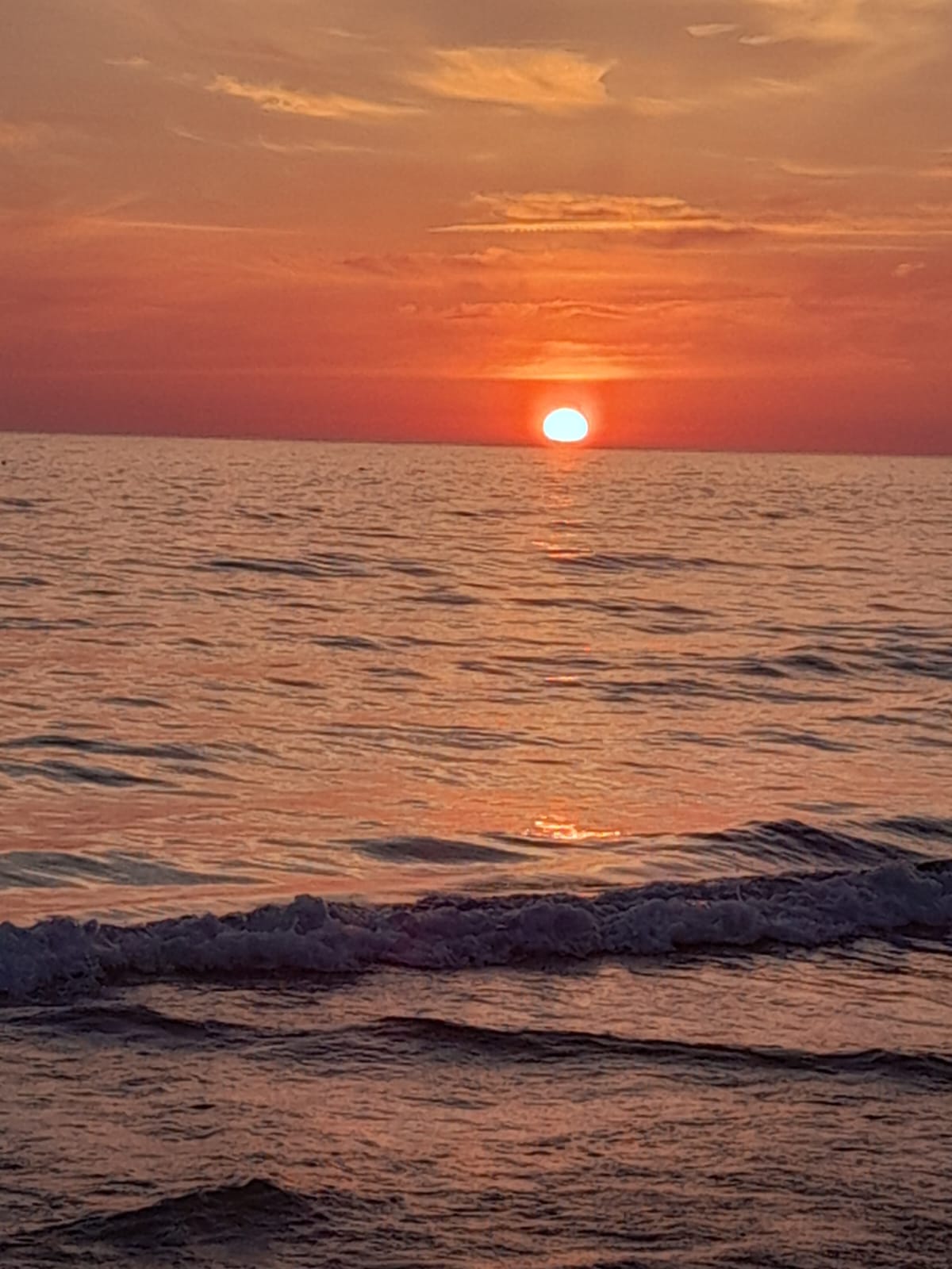 Il sole rosso che si tuffa nel mare a Cala Poliscia