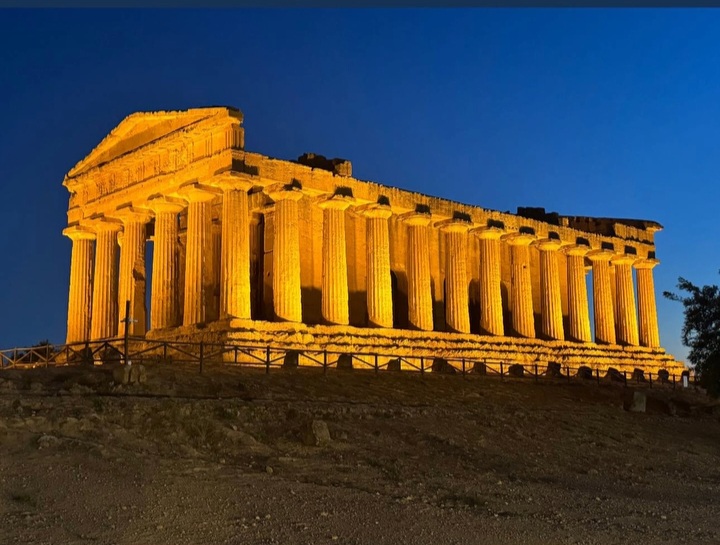 Il Tempio della Concordia illuminato di sera contro il cielo blu, nella Valle dei Templi di Agrigento